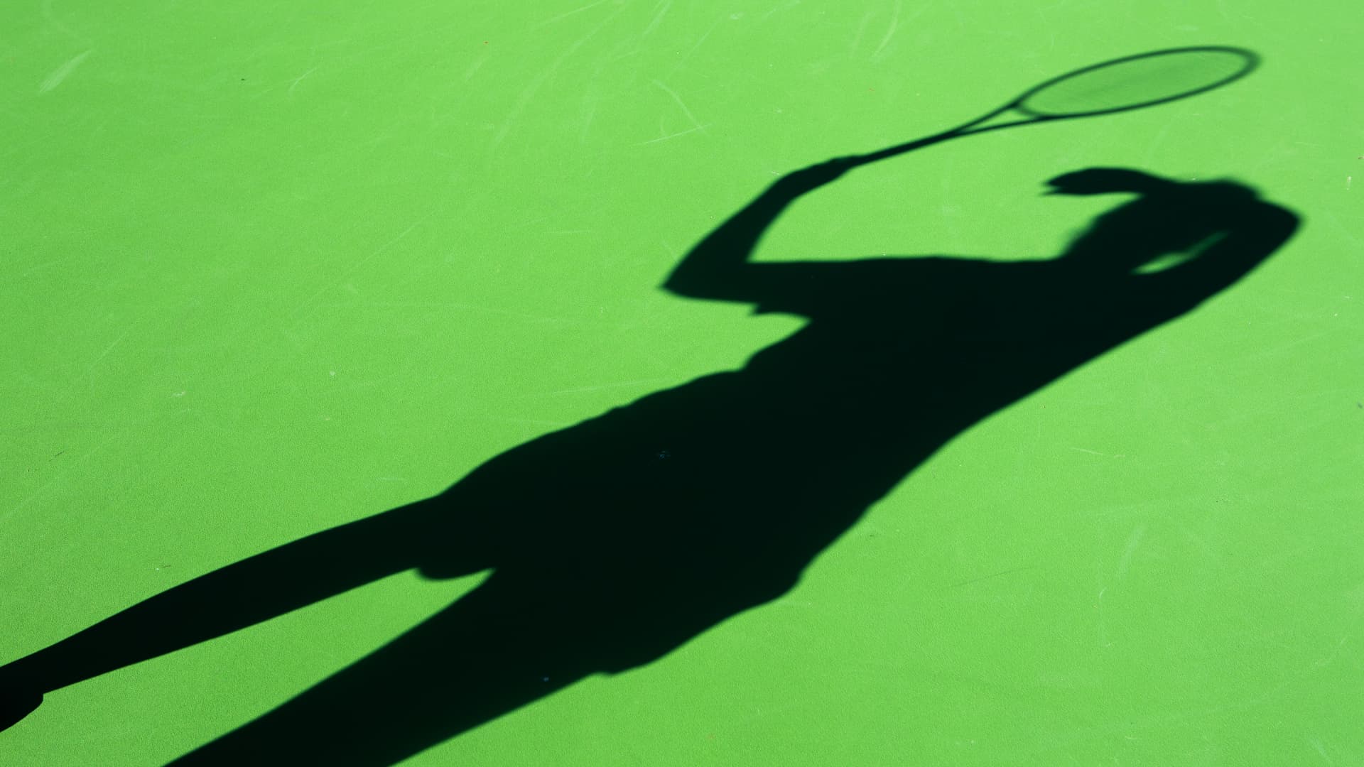 Skugga av tennisspelare på banan