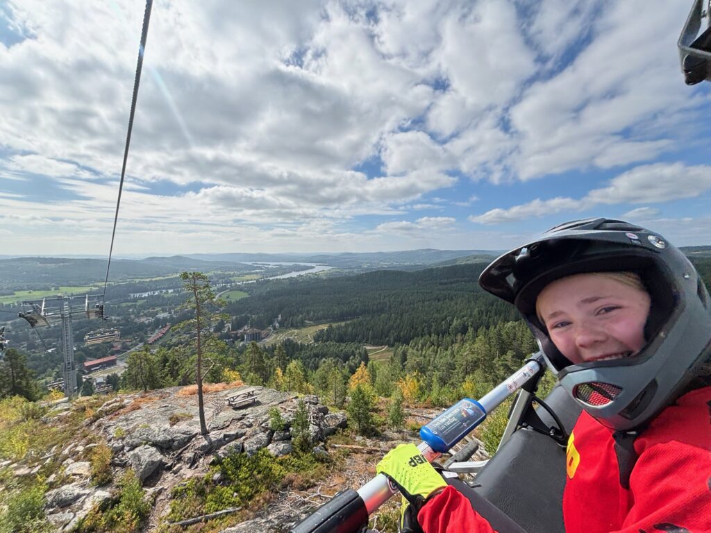Leende deltagare i liften med utsikt över dalen