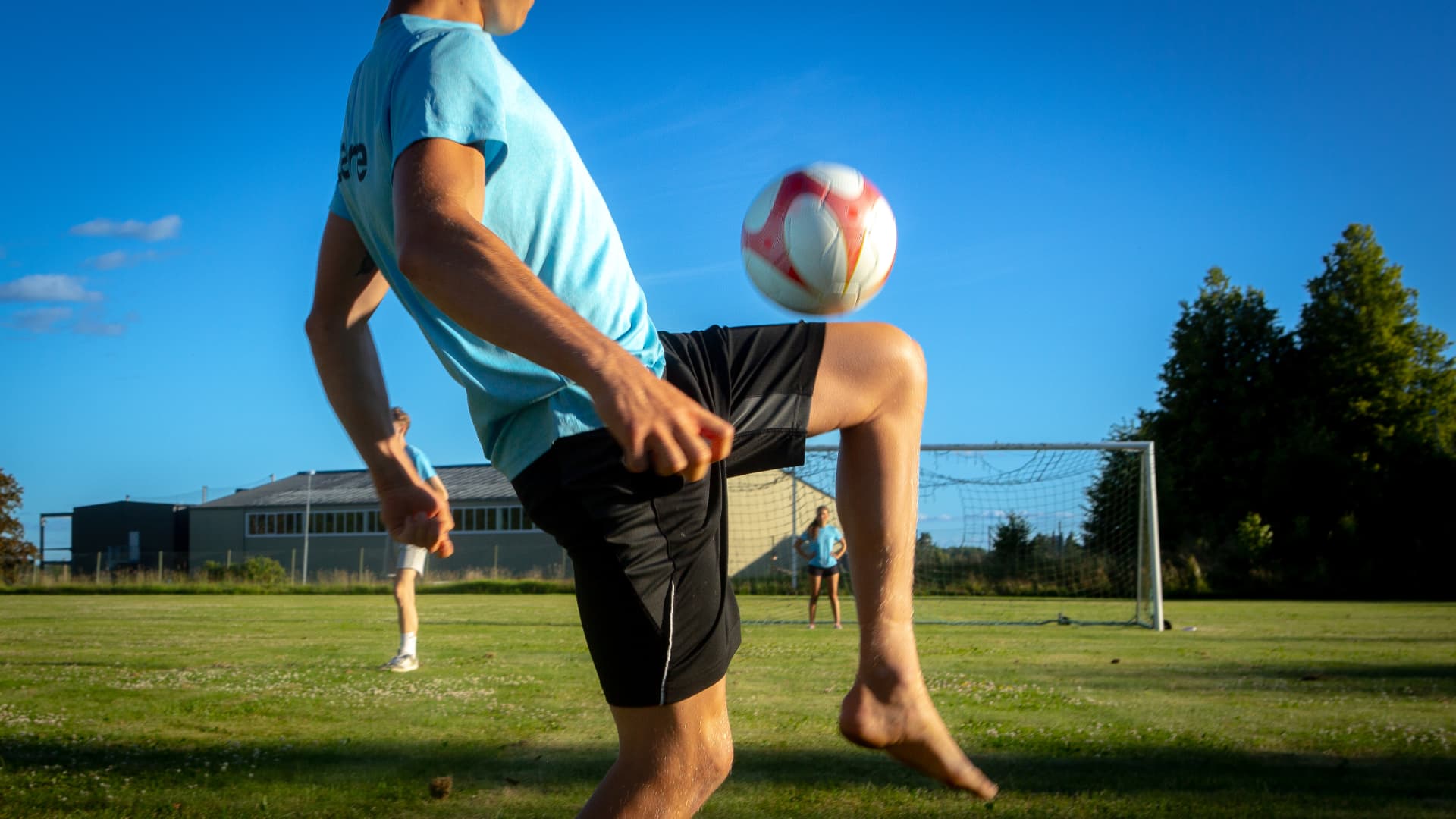 Fotbollsspelare nickar bollen på lägerplanen